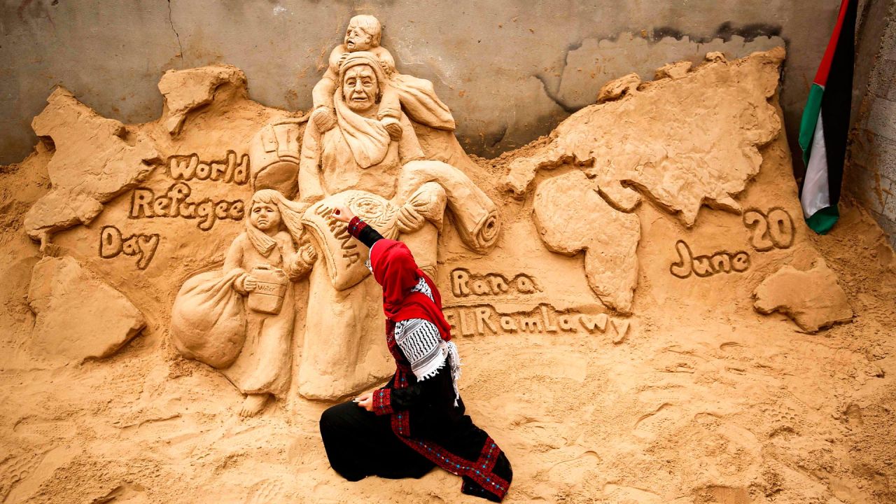La escultora de arena palestina Rana Ramlawi termina una nueva creación artística que conmemora el Día Mundial de los Refugiados. | Foto:MOHAMMED ABED / AFP