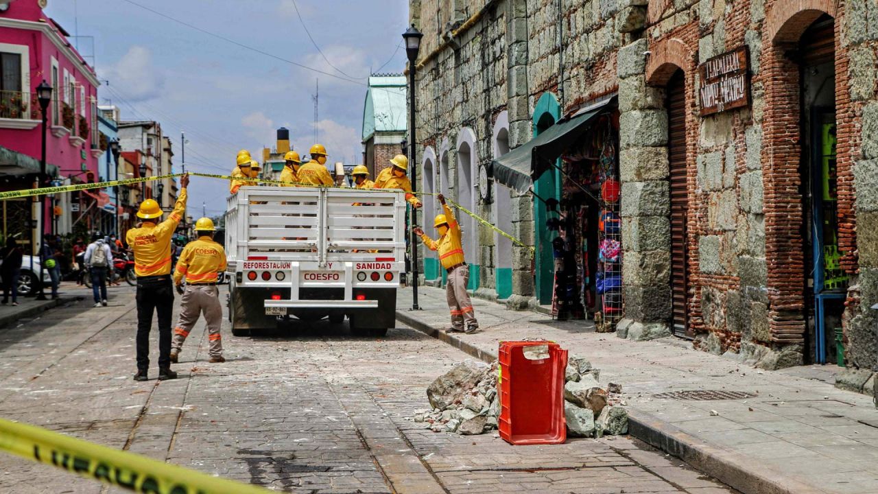 Los trabajadores retiran los escombros y colocan cintas de seguridad alertando sobre un edificio dañado después de un terremoto en Oaxaca, México. | Foto:PATRICIA CASTELLANOS / AFP