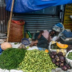 Un vendedor de verduras descansa en su puesto en una calle de Siliguri. | Foto:Diptendu Dutta / AFP