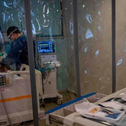 Una enfermera de la Unidad de Pacientes Críticos del Hospital Barros Luco, verifica la intubación de un paciente infectado con COVID-19, en Santiago. - Un número creciente de muertes por COVID-19 está dejando el sistema de salud chileno en el Parpadeo del colapso. | Foto:Martin Bernetti / AFP