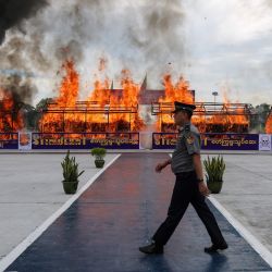 Un oficial de policía camina frente a un montón de drogas ilegales incautadas durante una ceremonia de destrucción para conmemorar el  | Foto:Sai Aung Main / AFP