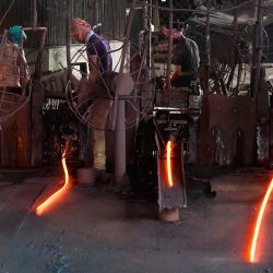 Los trabajadores operan maquinaria para producir varillas de acero en un laminador en Narayanganj, en las afueras de Dacca. | Foto:MUNIR UZ ZAMAN / AFP