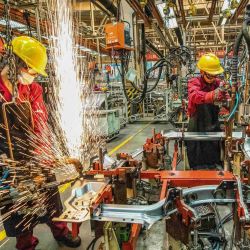 Los empleados trabajan en un taller de soldadura en una fábrica de automóviles en Weifang, en la provincia oriental china de Shandong. | Foto:STR / AFP