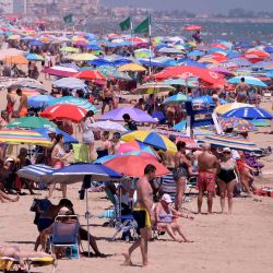 La gente disfruta de un día en Nord Beach en Gandia, cerca de Valencia. - La Unión Europea reabrió sus fronteras a los visitantes de 15 países, pero excluyó a los Estados Unidos, donde las muertes por coronavirus están aumentando una vez más, seis meses después del primer clúster se informó en China. | Foto:JOSE JORDAN / AFP