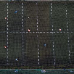 Amateur footballers play a new lockdown-acceptable form of the sport at the Play Futbol 5 local club in Pergamino. In order to continue playing amid government restrictions to curb the spread of the new coronavirus, the club divided its soccer field into 12 rectangles to mark limited areas for each player, keeping them from making physical contact. 