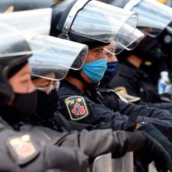 La policía antidisturbios espera mientras el personal médico de diferentes instituciones protesta contra el reciclaje de máscaras faciales en medio de la pandemia de coronavirus COVID-19 a lo largo de la Avenida Reforma en la Ciudad de México. | Foto:ALFREDO ESTRELLA / AFP