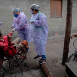 Los profesionales de la salud administran las pruebas COVID-19 a un anciano indígena guaraní en el campamento de la tribu Sao Mata Verde Bonita, en tierra indígena guaraní, en Marica, estado de Río de Janeiro, Brasil. | Foto:MAURO PIMENTEL / AFP