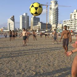Jóvenes israelíes juegan footvolley en la playa en la ciudad central de Tel Aviv. (Foto de MENAHEM KAHANA / AFP) | Foto:afp