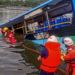 Los equipos de rescate trabajan después de que un autobús se hundiera en un lago en Anshun, en la provincia de Guizhou, suroeste de China. - Al menos 21 personas murieron cuando un autobús que transportaba estudiantes a su examen anual de ingreso a la universidad se hundió en un lago en el suroeste de China. | Foto:STR / AFP