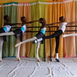 Los estudiantes se estiran durante los ensayos en la Academia Leap of Dance en Ajangbadi, Lagos. - La Academia Leap of Dance es una escuela de ballet en un distrito pobre de la extensa megaciudad de Lagos que tiene como objetivo llevar la danza clásica a niños desfavorecidos en La nación más poblada de África. | Foto:Benson Ibeabuchi / AFP