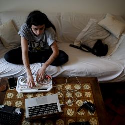 Delfina Espina plays music at home during the government-ordered, in Buenos Aires, Tuesday, June 30, 2020. Although Espina normally works as a DJ at parties and loves contact with people, she says the quarantine has helped her work on herself.