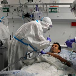 Los miembros del equipo médico simulan el tratamiento de covid-19 en un voluntario durante una sesión de entrenamiento. | Foto:JALAA MAREY / AFP