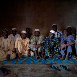 El jefe de la aldea, Adama Traore, posa junto con los concejales en su casa en Fana. | Foto:MICHELE CATTANI / AFP