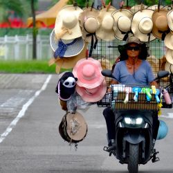 Wang Shang-chi, de 75 años, vendedor ambulante de sombreros, monta su bicicleta en un estacionamiento al lado del zoológico de la ciudad de Taipei. | Foto:Sam Yeh / AFP