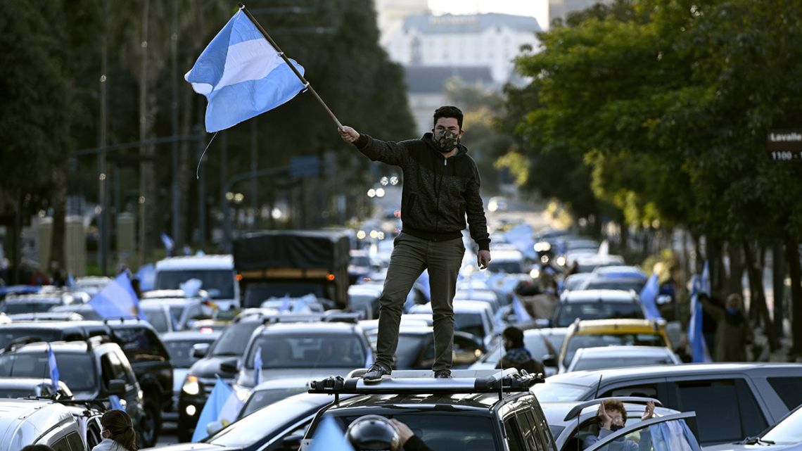 A man waves the Argentine flag during a protest against President Alberto Fernández health policies and the tightened virus lockdown measures against the spread of the Covid-19 coronavirus, in Buenos Aires on July 9, 2020.