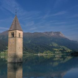 Una fotografía aérea tomada en la nueva ciudad de Curon Venosta (Graun im Vinschgau), a unos 100 km al noroeste de Bolzano, en el norte de Italia, muestra el campanario de la antigua iglesia de la ciudad de Curon sumergida en el lago Resia. | Foto:MIGUEL MEDINA / AFP
