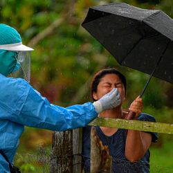 Un trabajador de salud recolecta una muestra de hisopo nasal para analizar COVID-19 a un residente, en el distrito de Arraijan, a 23 km al oeste de la ciudad de Panamá. | Foto:Luis Acosta / AFP