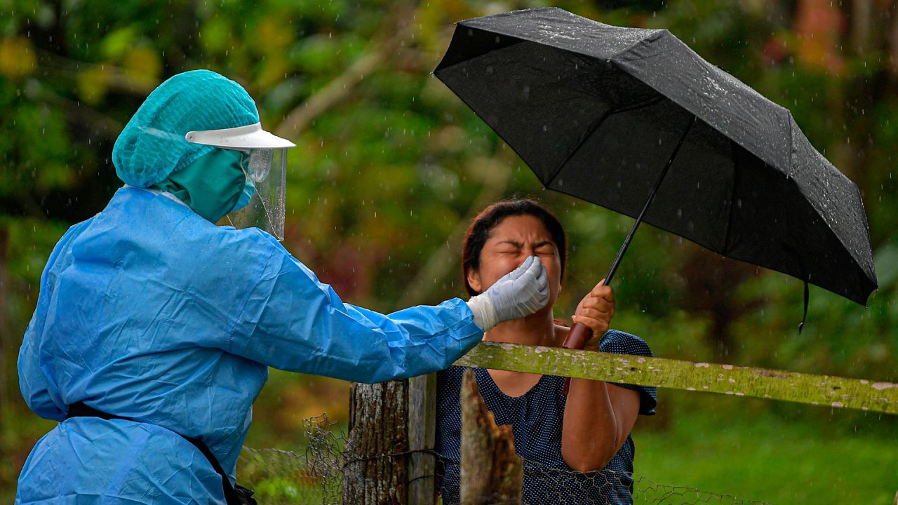 Un trabajador de salud recolecta una muestra de hisopo nasal para analizar COVID-19 a un residente, en el distrito de Arraijan, a 23 km al oeste de la ciudad de Panamá. | Foto:Luis Acosta / AFP