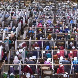 Los trabajadores enrollan tabaco en sus terminales de trabajo, separados por cubiertas de plástico como parte de las medidas en medio de la pandemia de coronavirus COVID-19, en una fábrica de cigarrillos Gudang Baru en Malang, Java Oriental. | Foto:AMAN ROCHMAN / AFP