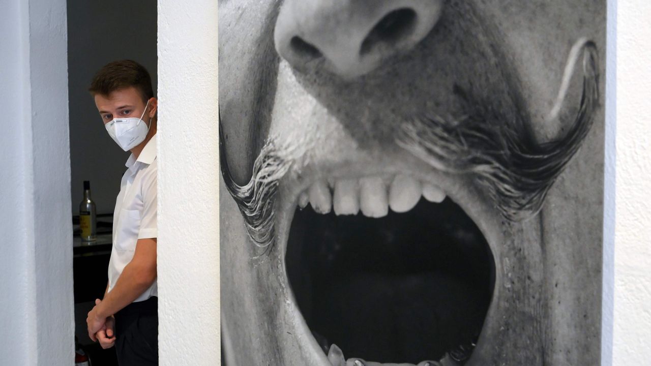 Un hombre con una máscara facial se encuentra junto a un retrato del artista español Salvador Dalí el día de la reapertura del museo Salvador Dalí en Figueras, después de estar cerrado durante más de tres meses debido a la nueva pandemia de coronavirus. | Foto:LLUIS GENE / AFP