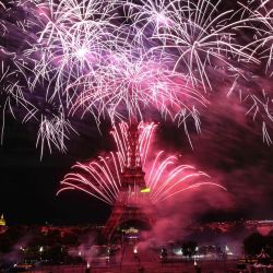 Los fuegos artificiales explotan sobre la Torre Eiffel como parte de las celebraciones anuales del Día de la Bastilla en París. | Foto:Anne-Christine Poujoulat / AFP