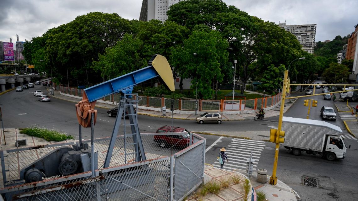 Drivers pass next by a small square with an oil pump in one of the access roads to the Central University of Venezuela, in Caracas on July 14, 2020.