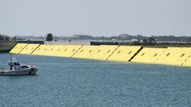 El proyecto consta de 78 barreras móviles de color amarillo enterradas en el agua.
