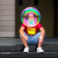 China, Beijing: Un hombre aparece detrás de una burbuja de jabón mientras fuma frente al cine en el centro comercial Solana. | Foto:Wiktor Dabkowski / Zuma Wire / DPA
