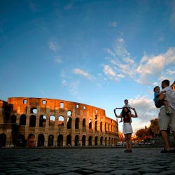 Una familia de turistas toma fotos junto al Arco de Constantino junto al Coliseo en el centro de Roma. | Foto:Filippo Monteforte / AFP