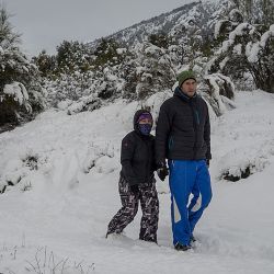 Una familia disfruta de la caminata en la nieve, en la Patagonia. Todo el país está en el receso escolar de invierno.