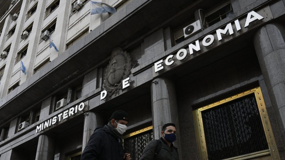 Men walk past Economy Ministry building during the lockdown imposed by the government against the spread of the new coronavirus, in Buenos Aires. 