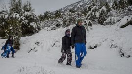 Una familia disfruta de la caminata en la nieve, en la Patagonia. Todo el país está en el receso escolar de invierno.