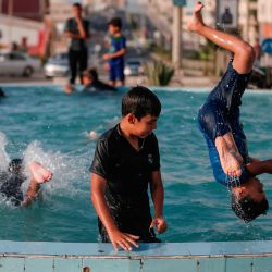 Niños palestinos juegan en una fuente pública durante un caluroso día de verano en la ciudad de Gaza. | Foto:MAHMUD HAMS / AFP