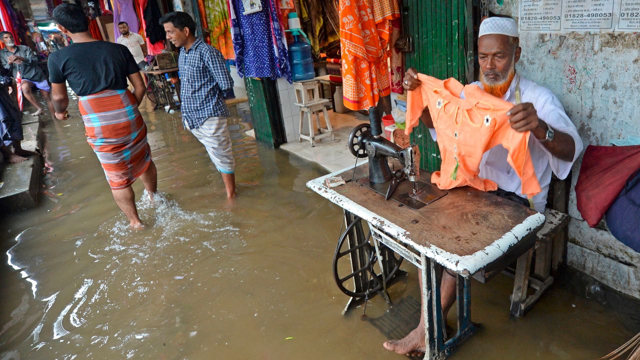 Los sastres trabajan fuera de una tienda en un centro comercial con agua después de una fuerte lluvia en Dhaka. - La cifra de muertos por las fuertes lluvias monzónicas en el sur de Asia ha aumentado a casi 200, dijeron funcionarios el 19 de julio, mientras Bangladesh y Nepal advirtió que el aumento de las aguas provocaría más inundaciones. | Foto:Munir Uz zaman / AFP