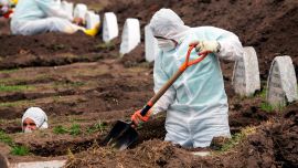 Los trabajadores que usan equipos de bioseguridad preparan tumbas para presuntas víctimas del nuevo coronavirus Covid-19, en el cementerio de San Diego, en el Centro Colonial de Quito.