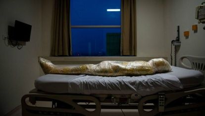 El cuerpo de una presunta víctima de Covid-19 yace en un hospital indonesio. Después de la muerte del paciente, las enfermeras del hospital envolvieron el cuerpo inerte en capas de plástico y aplicaron desinfectante para evitar la propagación del virus.