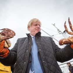 El primer ministro del Reino Unido, Boris Johnson, tiene cangrejos atrapados en Carvela en el puerto de Stromness en Stromness durante una visita a las Highlands y las islas del norte de Escocia. | Foto:Robert Perry / PA Wire / DPA