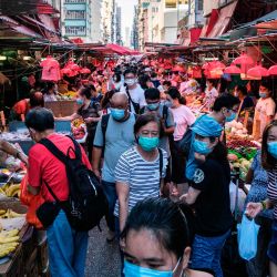 La gente compra frutas y verduras en un mercado callejero en Hong Kong. | Foto:ANTHONY WALLACE / AFP
