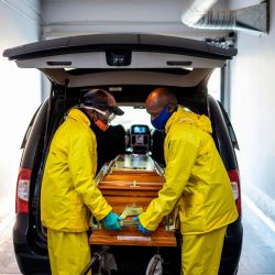 Los emprendedores cargan el ataúd que contiene los restos de Modise Motlhabane, quien murió de coronavirus COVID-19, en un coche fúnebre en la casa funeraria AVBOB en Soweto. | Foto:Michele Spatari / AFP