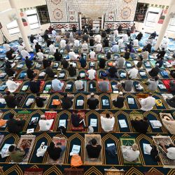 Los fieles socialmente distanciados y con máscaras faciales se arrodillan sobre sus esteras de oración personales durante las oraciones del viernes en Madina Masjid, la mezquita central de Sheffield, en Sheffield, norte de Inglaterra. | Foto:OLI SCARFF / AFP