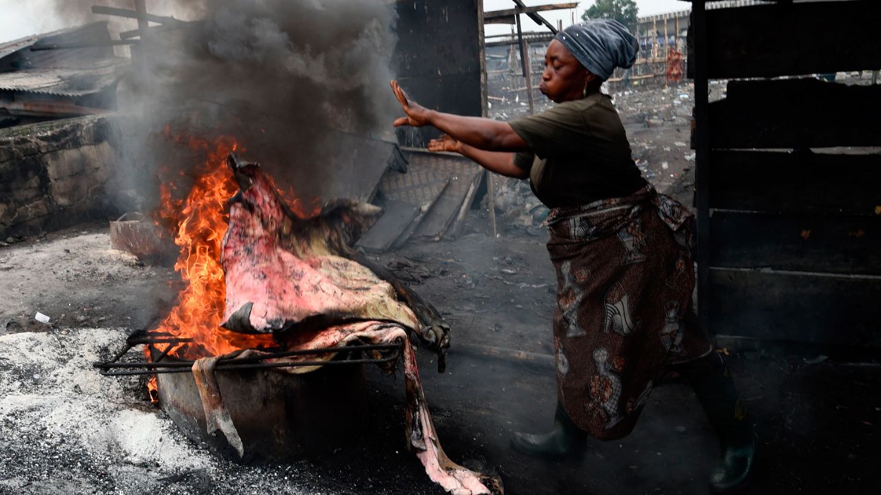 Una mujer arroja piel de vaca al fuego para quemar la cubierta exterior peluda en un matadero en Kara, estado de Ogun, en el suroeste de Nigeria. | Foto:PIUS UTOMI EKPEI / AFP