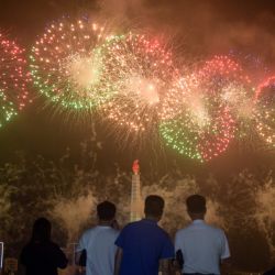 La gente mira un espectáculo de fuegos artificiales frente a la torre Juche con motivo del 67 aniversario de la firma del acuerdo de armisticio de la Guerra de Corea, un evento al que Corea del Norte se refiere como 'la victoria del pueblo coreano del gran Guerra de Liberación de la Patria ', en Pyongyang. | Foto:Kim Won Jin / AFP