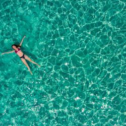 Una vista aérea muestra a una mujer disfrutando del mar en una playa de la pequeña isla de Chrysi, al sur de Creta. | Foto:ARIS MESSINIS / AFP