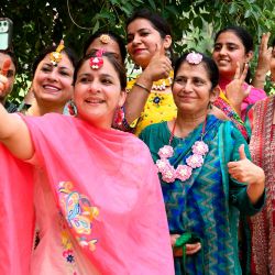 Los profesores universitarios toman fotos selfie durante el festival Teej para conmemorar el mes de Sawan (lluvia) en el Khalsa College for Women en Amritsar. | Foto:NARINDER NANU / AFP