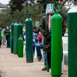 Familiares de pacientes de COVID-19 hacen cola para recargar cilindros de oxígeno en Villa María del Triunfo, en las afueras del sur de Lima. | Foto:Ernesto Benavides / AFP