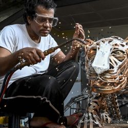 El artesano Lalith Senannnayake suelda chatarra de metal para hacer una escultura en forma de leopardo en su casa de Wattala, cerca de Colombo. | Foto:Ishara S. Kodikara / AFP