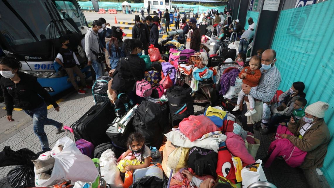 Venezuelan migrants wait for a bus to travel to the border, in Bogotá, Colombia,. Facing no work due to the COVID-19-related economic shutdown, hundreds of Venezuelan migrants are returning to their country.
