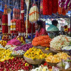 Los vendedores venden guirnaldas de flores en un mercado antes de 'Vara Mahalakshmi Vratha', un ritual hindú realizado para apaciguar a la Diosa de la riqueza y la prosperidad Lakshmi, en Bangalore. | Foto:Manjunath Kiran / AFP
