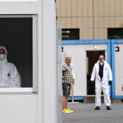 Un empleado de una organización de ayuda se encuentra en una ventana en una estación de pruebas Corona recientemente establecida en Dortmund, Alemania occidental, en medio de la nueva pandemia de coronavirus COVID-19. | Foto:INA FASSBENDER / AFP