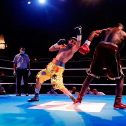 El boxeador francés Milan Prat pelea con el boxeador francés Jonathan Okito durante la noche de boxeo de Fighting Nation, el primer evento interior codicioso, dentro del circo Bormann en París. | Foto:GEOFFROY VAN DER HASSELT / AFP